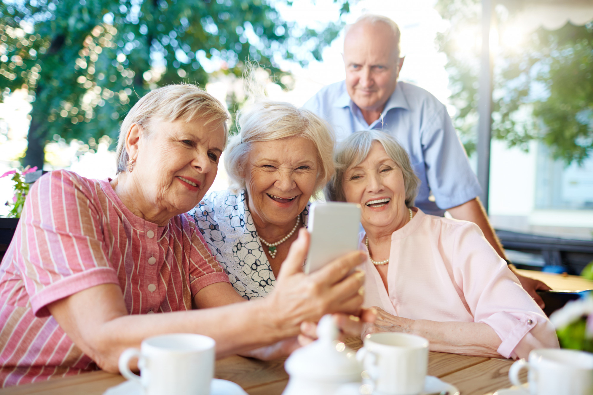 Seniorzy korzystają ze smartfona.
